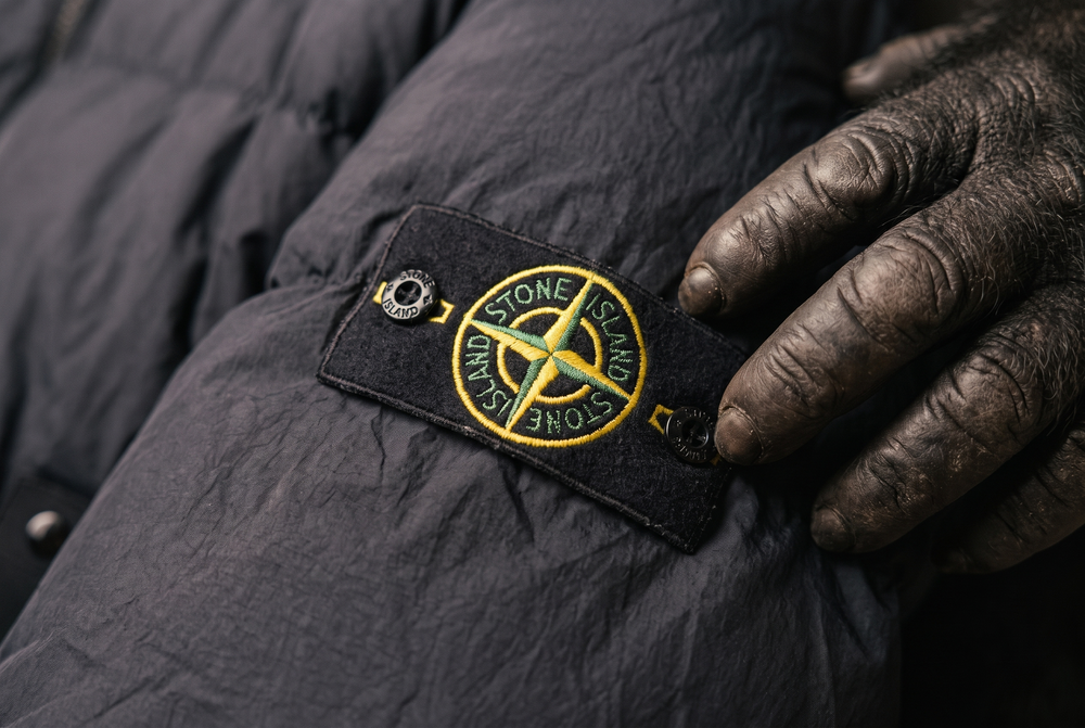 Close up of a Stone Island compass badge buttoned to the sleeve of a jacket