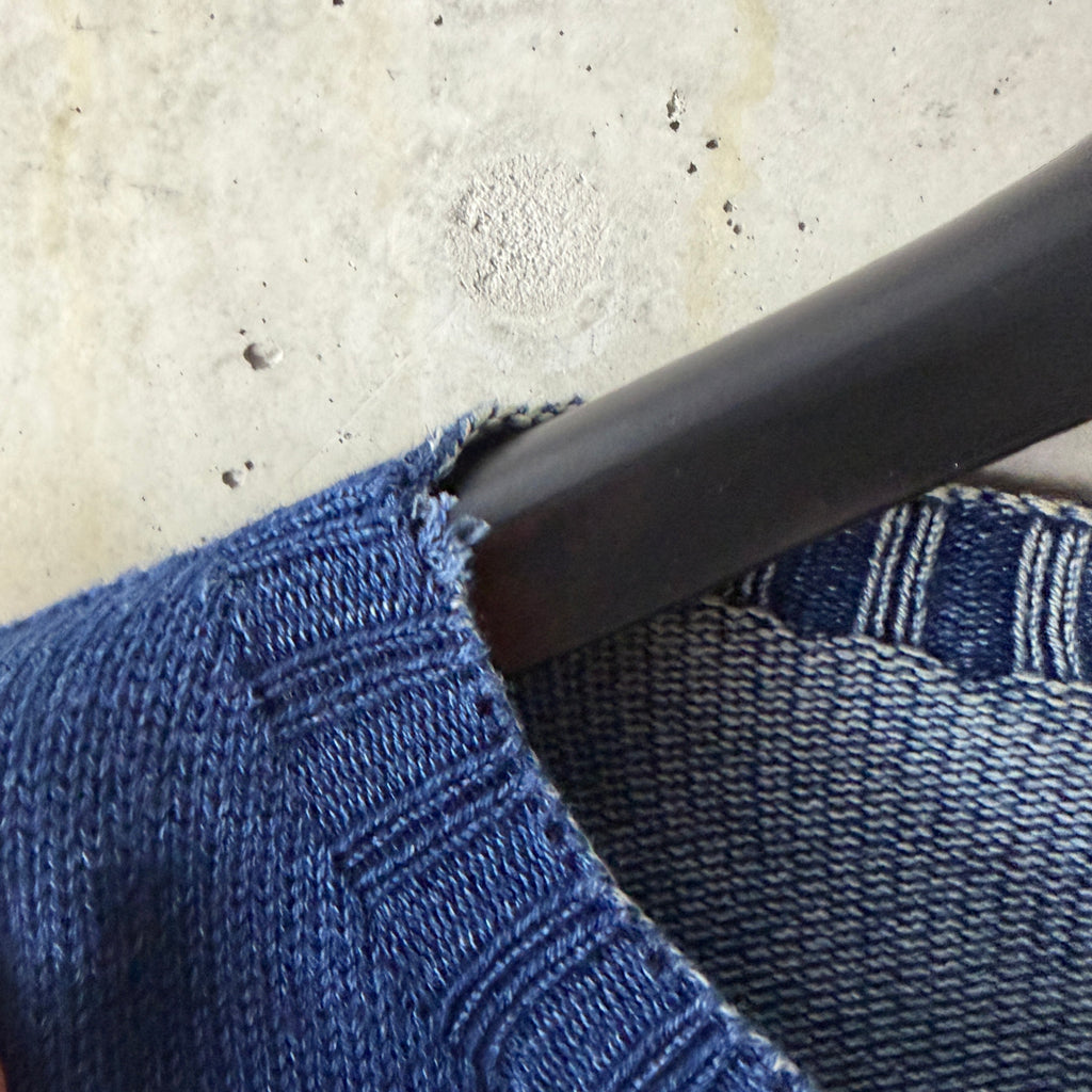 Close-up of the neckline showing the small opening in the rolled collar edge